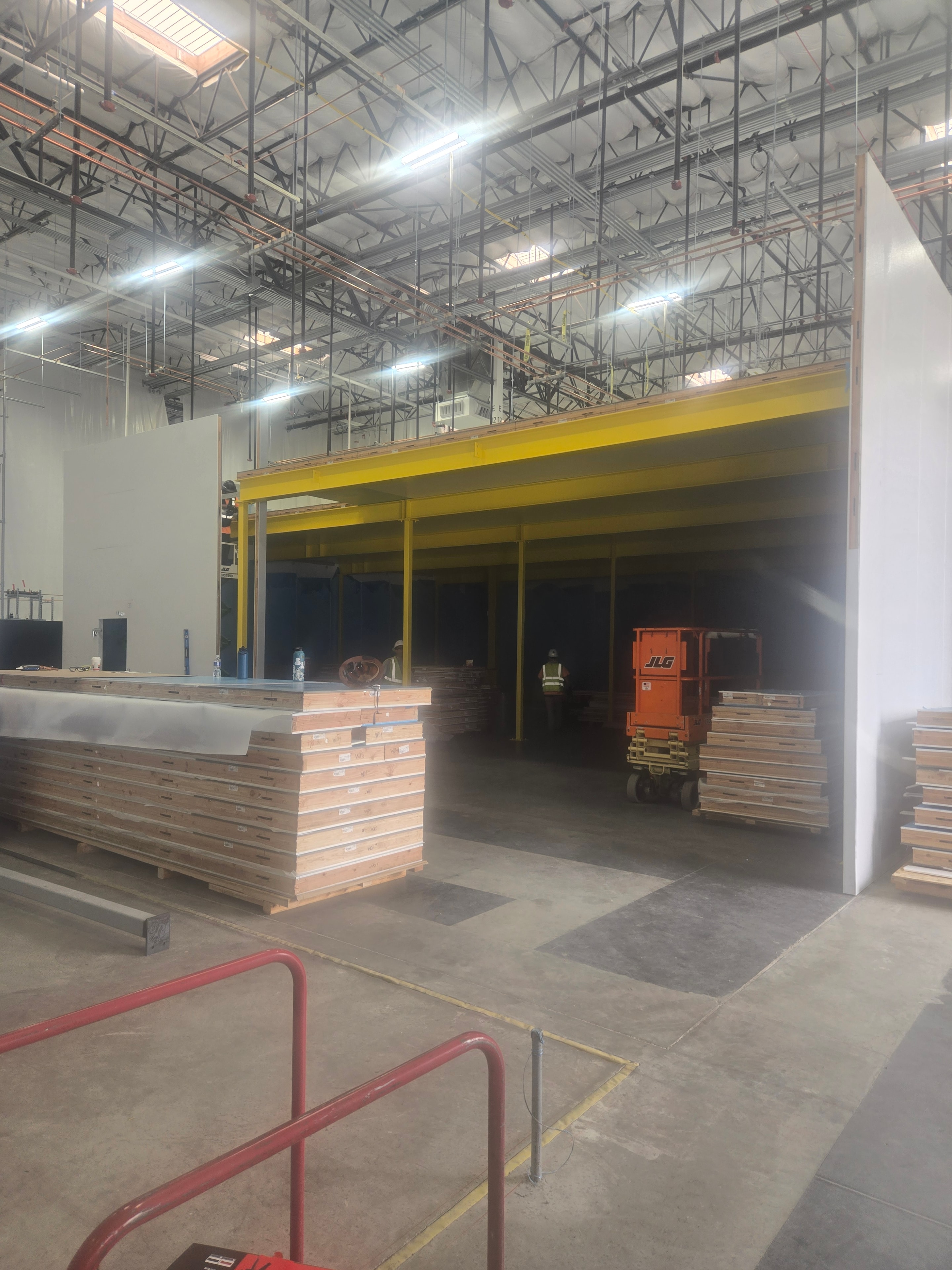 Walk-in cooler panels being set into place with forklift inside Amazon facility