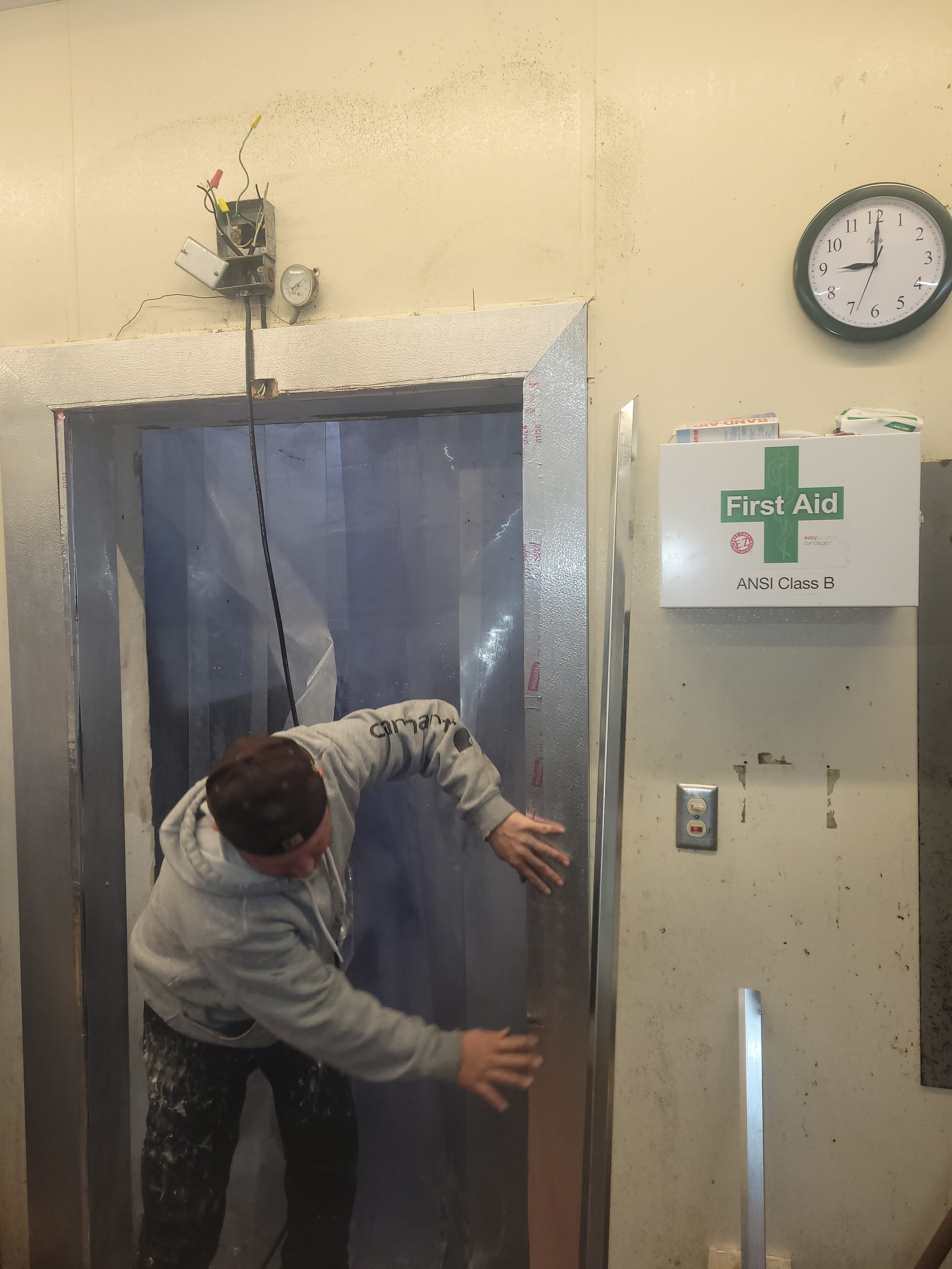 Technician installing new walk-in freezer door