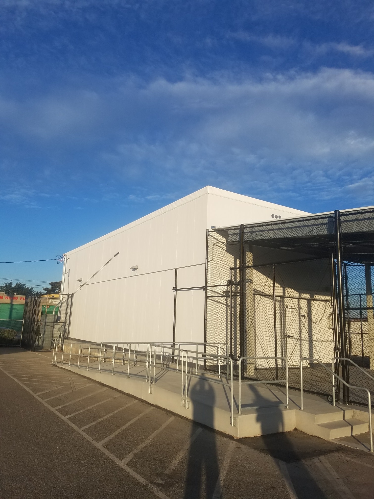 Completed commercial warehouse exterior with access ramp and fencing